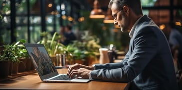 a person in a suit typing on a laptop