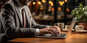 a person in a suit typing on a laptop