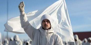 a person in a white jacket holding a white flag