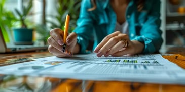 Woman analyzing charts and graphs with pen.