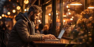 a person sitting at a table with a laptop