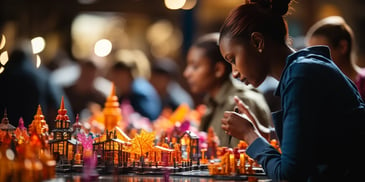 a group of people sitting at a table looking at a model of buildings