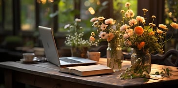 a laptop and flowers on a table