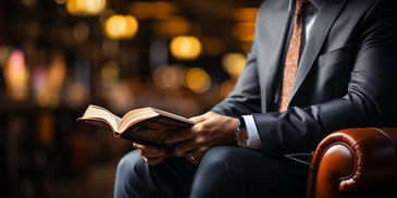 a person in a suit reading a book