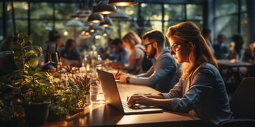 a person sitting at a table with a laptop