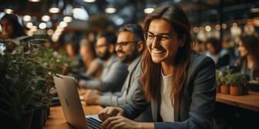 a person smiling at a laptop