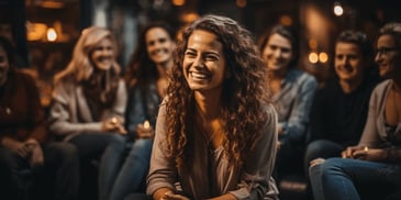 a person smiling with other people behind her