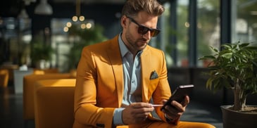 a person in a yellow suit and sunglasses looking at a phone