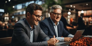 a group of men looking at a laptop